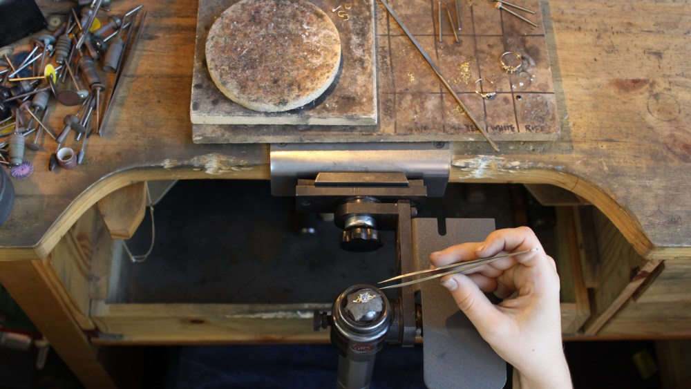 A Catbird jeweler sets a ring.