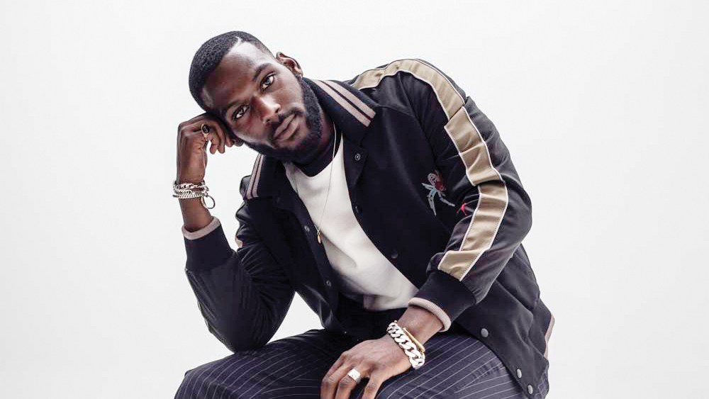 Kofi Siriboe in Lanvin's satin, cotton and glass bead embroidery jacket and 3.1 Phillip Lim's cotton T-shirt and wool pants.