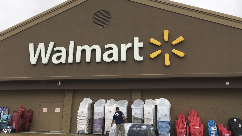 A worker stacks merchandise outside a Walmart in Salem, N.H. Walmart is providing workers with an app aimed at helping them budget their money and get paid before paydayWalmart-Worker Finances, Salem, USA - 05 Jun 2017