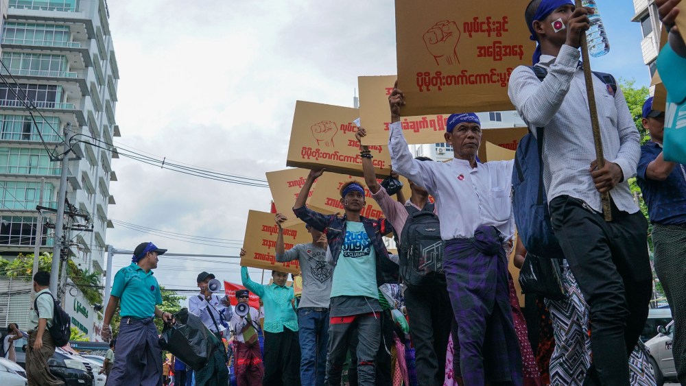 Workers with minimum wage slogans marching in downtown Yangon.