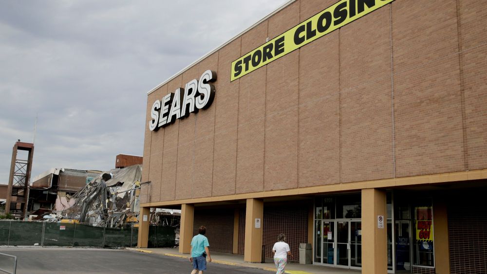 People walk into a Sears store slated for closing that is next to a mall that is being torn down in Overland Park, Kan. Sears has filed for Chapter 11 bankruptcy protection, buckling under its massive debt load and staggering losses. The company once dominated the American landscape, but whether a smaller Sears can be viable remains in questionSears, Overland Park, USA - 07 Jul 2017