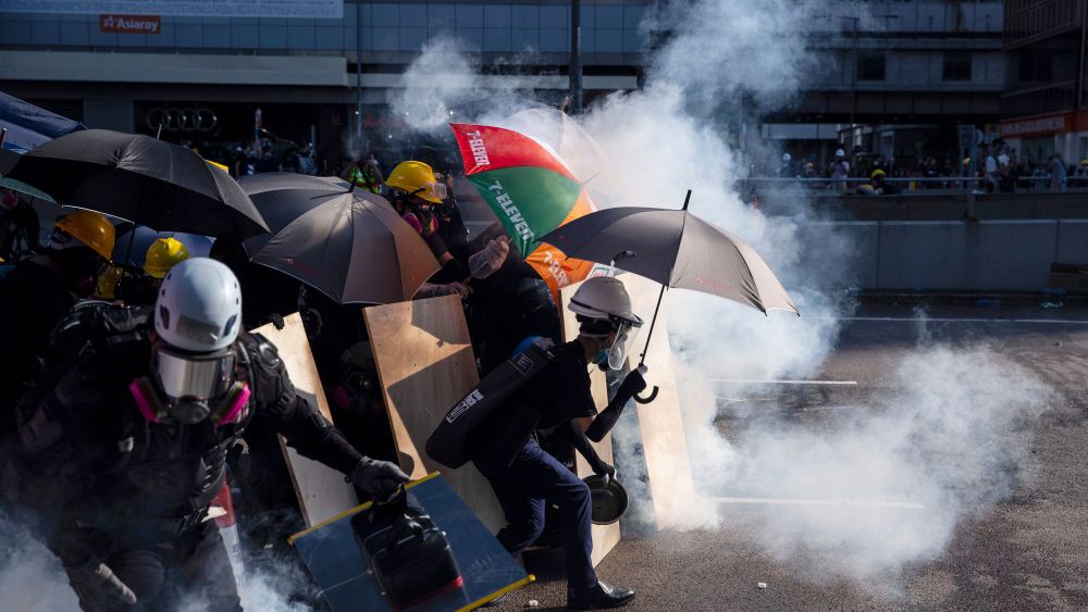 Anti-extradition protesters react after police fired tear gas at them in the Admiralty area of Hong Kong, China
