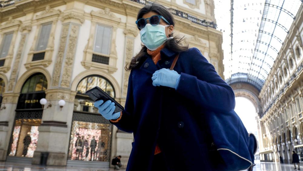 A woman wearing a face mask walks past the deserted Galleria Vittorio Emanuele II amid coronavirus outbreak, in Milan, Italy, 11 March 2020.Coronavirus in Italy, Milan - 11 Mar 2020