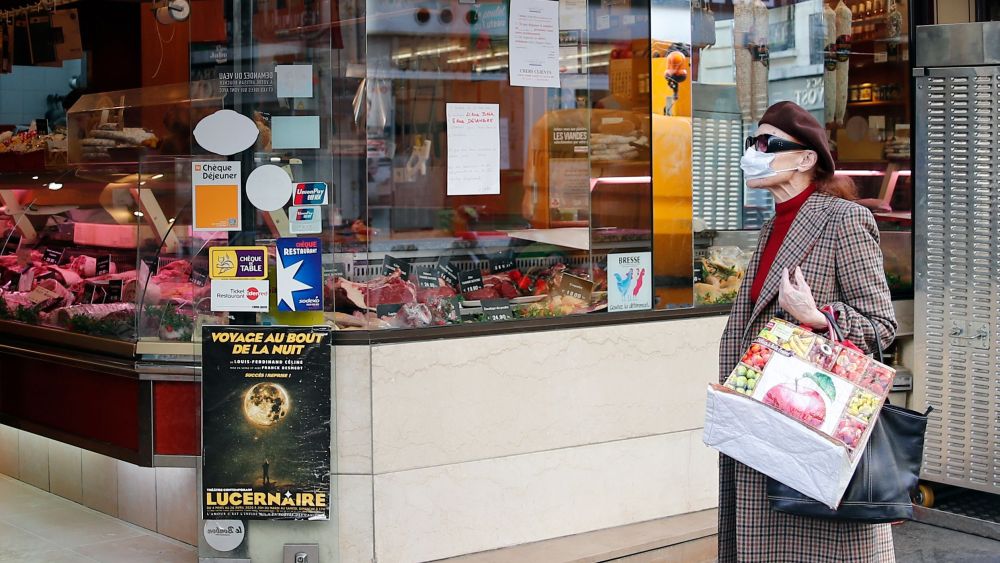 A woman walks with grocery bags amid coronavirus outbreak in Paris
