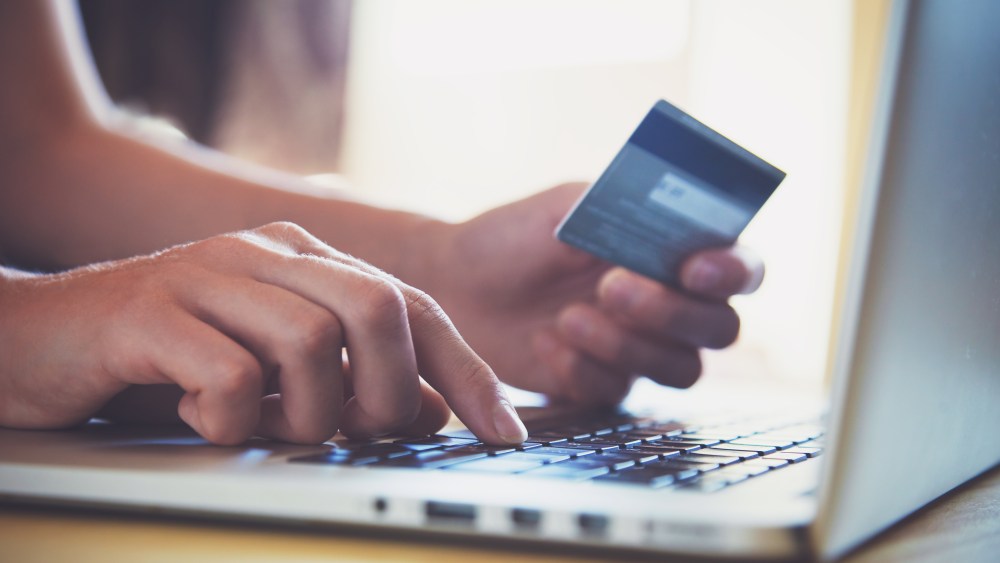 Hands holding credit card and using laptop. Online shopping
