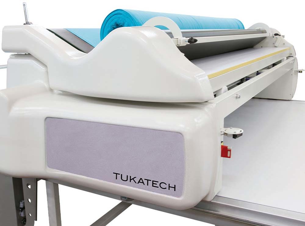 The Tukaspread automatic fabric spreading machine is designed to remove fabric relaxation, with the most recent update increasing its capacity to hold up to 600 kilograms. The smart tension controller lays fabric evenly without pulling, including for fabrics like modal, which has four-way stretch.