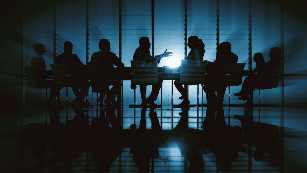 Silhouette of business people in a dark meeting room