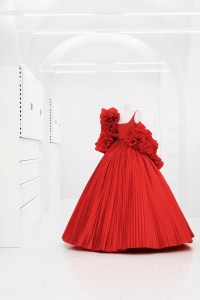 A red ballgown features flower-like detail at the bodice from Valentino Des Ateliers Haute Couture Fall-Winter 2021-22, mod 72-A7 Debora, Bianca, Nina, Riccardo, Sara.