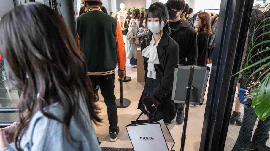 A woman holding Shein shopping bags leaves the first permanent showroom of Chinese online fast fashion giant Shein on the opening day of the shop in Tokyo on Nov. 13, 2022.