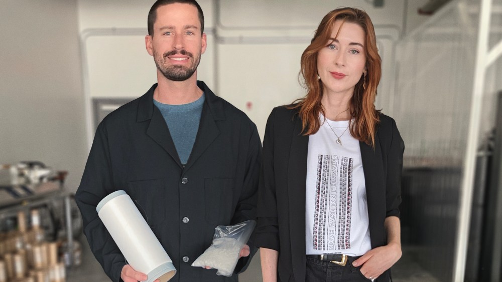 Dressed in black lab coats, Kintra Fibers cofounders Billy McCall and Alissa Baier-Lentz, hold materials for Kintra production.