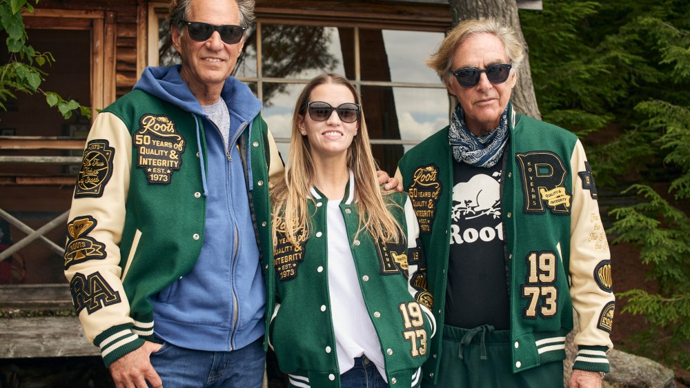 Don Green (Roots Co-Founder), Meghan Roach (Roots President & CEO), Michael Budman (Roots Co-Founder), Original Cabin at Algonquin Park, Canada (where Don Green and Michael Budman first had the idea to build Roots).