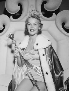 (Original Caption) Miss U.S.A. Long Beach, California: Statuesque Carlene King Johnson, "Miss Vermont," sits enthroned as Miss United States after her selection at Long Beach, California. The 22 year old jewelry designer, 5'5" tall, was not one of the finalists in the Miss Universe contest. The Rutland, Vermont, beauty won a $200 a week contract with Universal-International Studios, a pearl necklace, a sterling silver compact and a gold trophy.