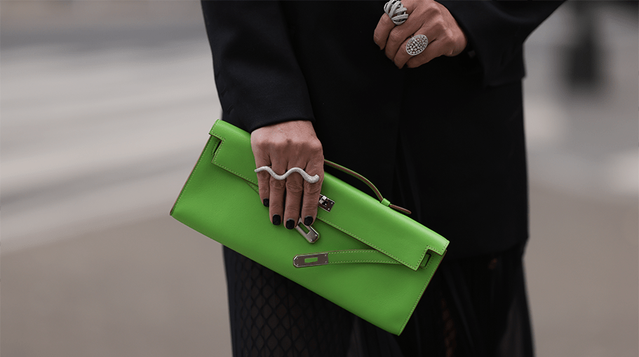 Corina Mihaila Larpin wearing Peter Do black blazer, Dior black bra and shorts, Hermès green leather clutch, YSL plateau black leather boots, Stefere diamond white gold rings and black diamond chain, Linda Farrow round shades and Schiaparelli gold statement belt on February 12, 2023 in New York City.