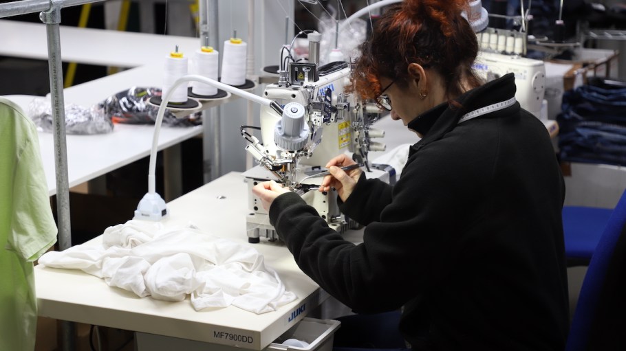 A woman sewing at Advanced Clothing Solutions.