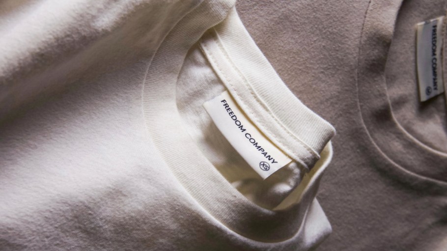 Two neutral-colored Freedom Company T-shirts.