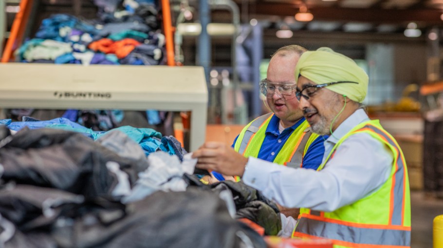Men work to recycle textile waste in an Eastman processing facility.