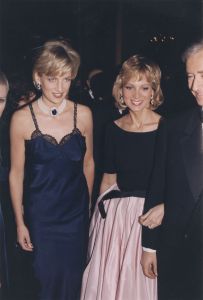 Princess Diana wearing a Black, lace-trimmed slip dress and large pearl and sapphire. pendant at the MET Costume Institute annual gala in New York and standing beside Helene Arnault in boat-neck blouse with a pale pink taffeta skirt..Article title: 'Suzy: Dior's New York LookPrincess Diana at the Met Gala, New York