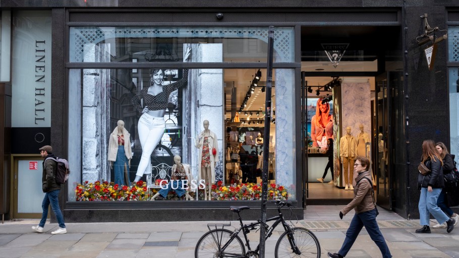 People interacting with mannequins and large scale pictures of female models in the shop window of the Guess store on Regent Street on 6th March 2024 in London, United Kingdom.