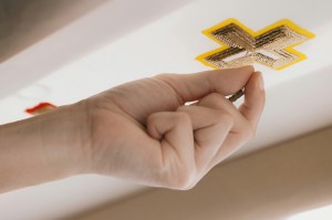 An embroiderer at Montex works on a cross motif.