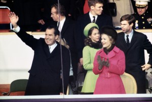 US President Richard Nixon  waves and First Lady Pat Nixon applauds as they arrive at the White House reviewing stand, Washington, January 20th 1969. At back are their daughter, Julie Eisenhower, and her husband David.