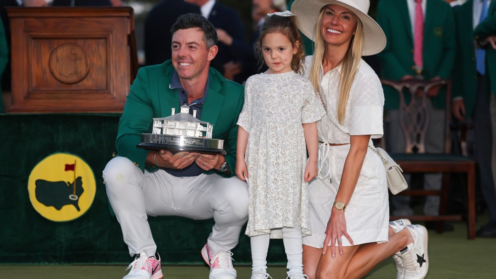 AUGUSTA, GEORGIA - APRIL 13: (L-R) Rory McIlroy of Northern Ireland poses with daughter Poppy and wife Erica Stoll holding the Masters trophy during the Green Jacket Ceremony after winning the 2025 Masters Tournament at Augusta National Golf Club on April 13, 2025 in Augusta, Georgia. (Photo by Michael Reaves/Getty Images)