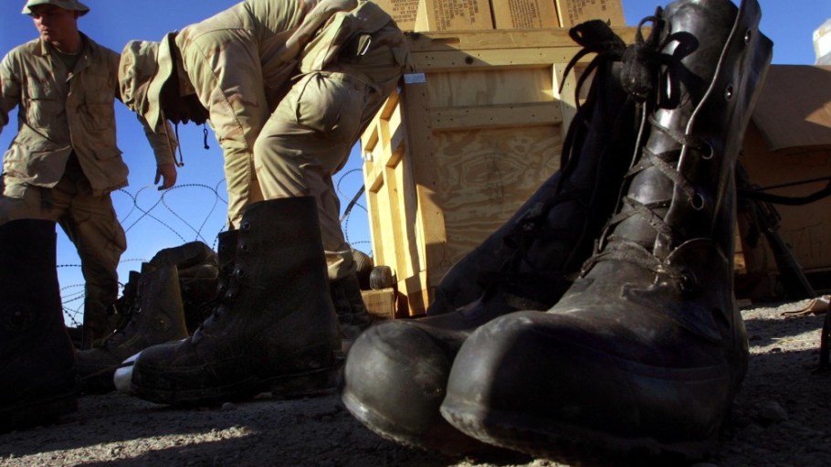 United States Army 101st Airborne Division members try on thermal boots issued to them on the American military compound at Kandahar Airport Jan. 19, 2002.