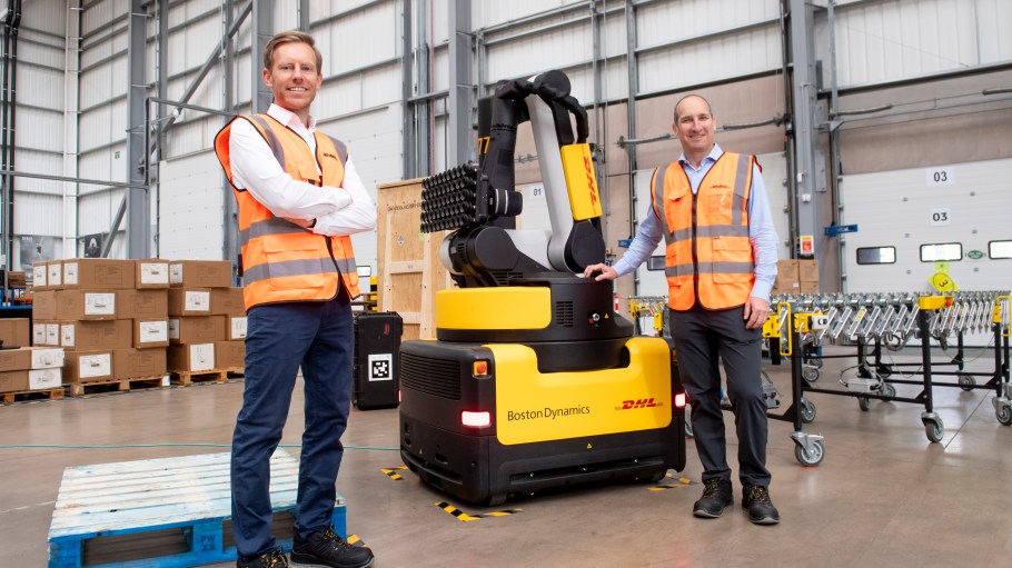 DHL's Saul Resnick and Tim Tetzlaff stand with a Boston Dynamics Stretch warehouse robot.
