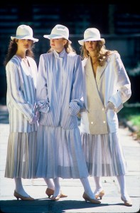 Models wearing long striped blazers with calf-length pleated skirts and white hats from the Perry Ellis Spring/Summer 1982 line outside in New York..photographed in September 1981