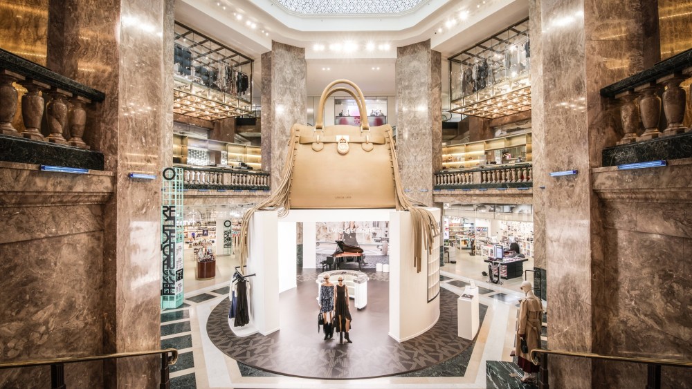 A Michael Kors pop-up at Galeries Lafayette Champs-Élysées in Paris features a giant handbag.