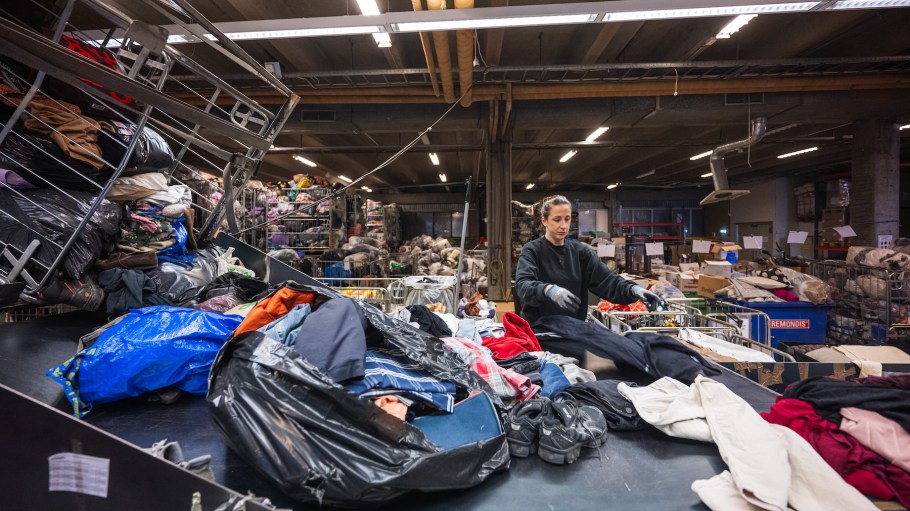 A worker sorts incoming clothing items at Artikel2’s sorting center in Stockholm on April 10, 2025.