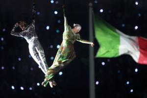 Two aerial actors perform next to the rings representing the city and mountain during the opening ceremony of the Milano Cortina 2026 Winter Olympics.