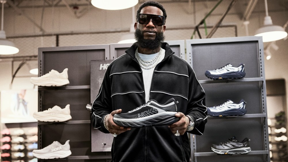 Gucci Mane posing with the Hoka Bondi 7 Stealth Tech sneaker.