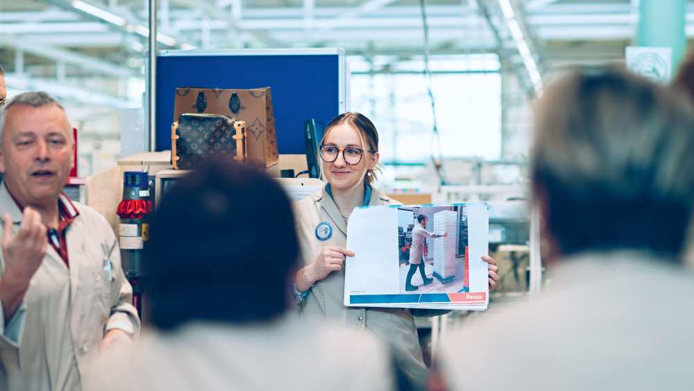 Members of a Louis Vuitton leather goods workshop attend a presentation on workplace welfare
