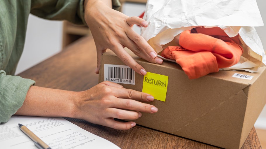 woman online shopper affixes a barcode sticker to a cardboard box, marking it for return and refund.