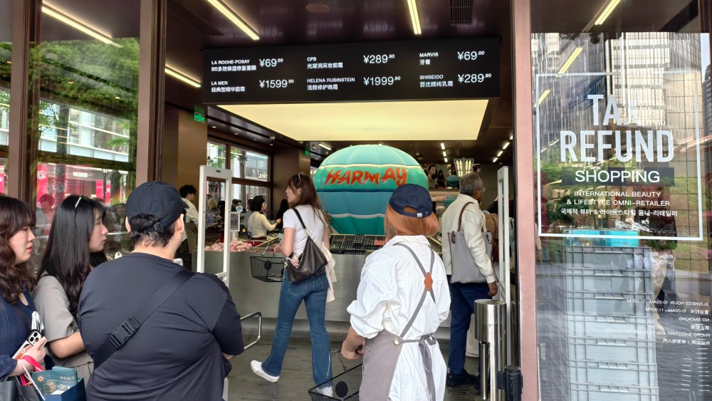 Foreign tourists queue up for entry and consumption at Harmay's Duty Free store in Shanghai, China