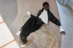 Celine lambskin jacket, silk twill shirt, diagonal wool trousers and brass charm bracelet; Mugler shoes; Clash de Cartier 14-karat rose gold and onyx earrings; Bulgari Tubogas 18-karat yellow gold bracelet; Serpenti Viper one-coil 18-karat yellow gold bracelet.